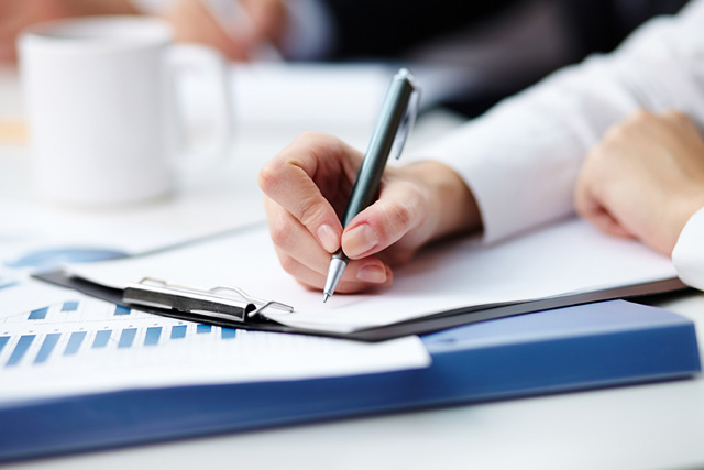 A person writing on a notepad.